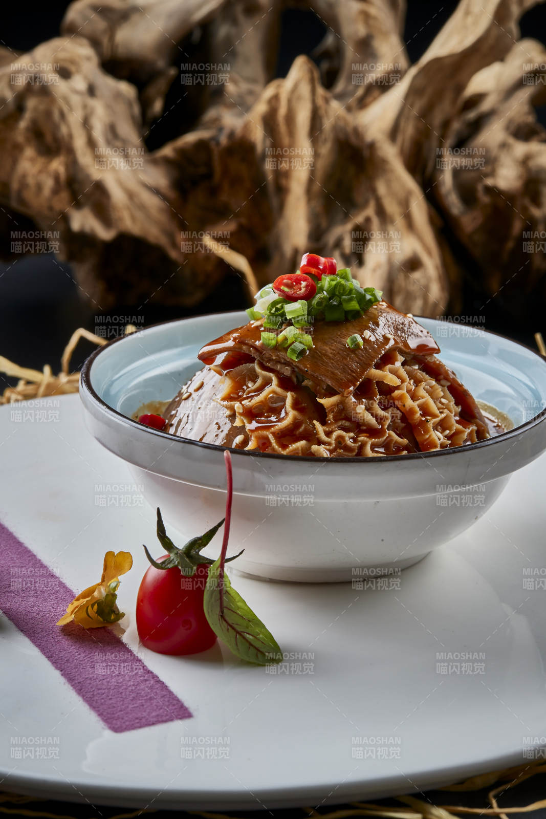 黑色背景上的瓷餐具装的川味夫妻肺片图片