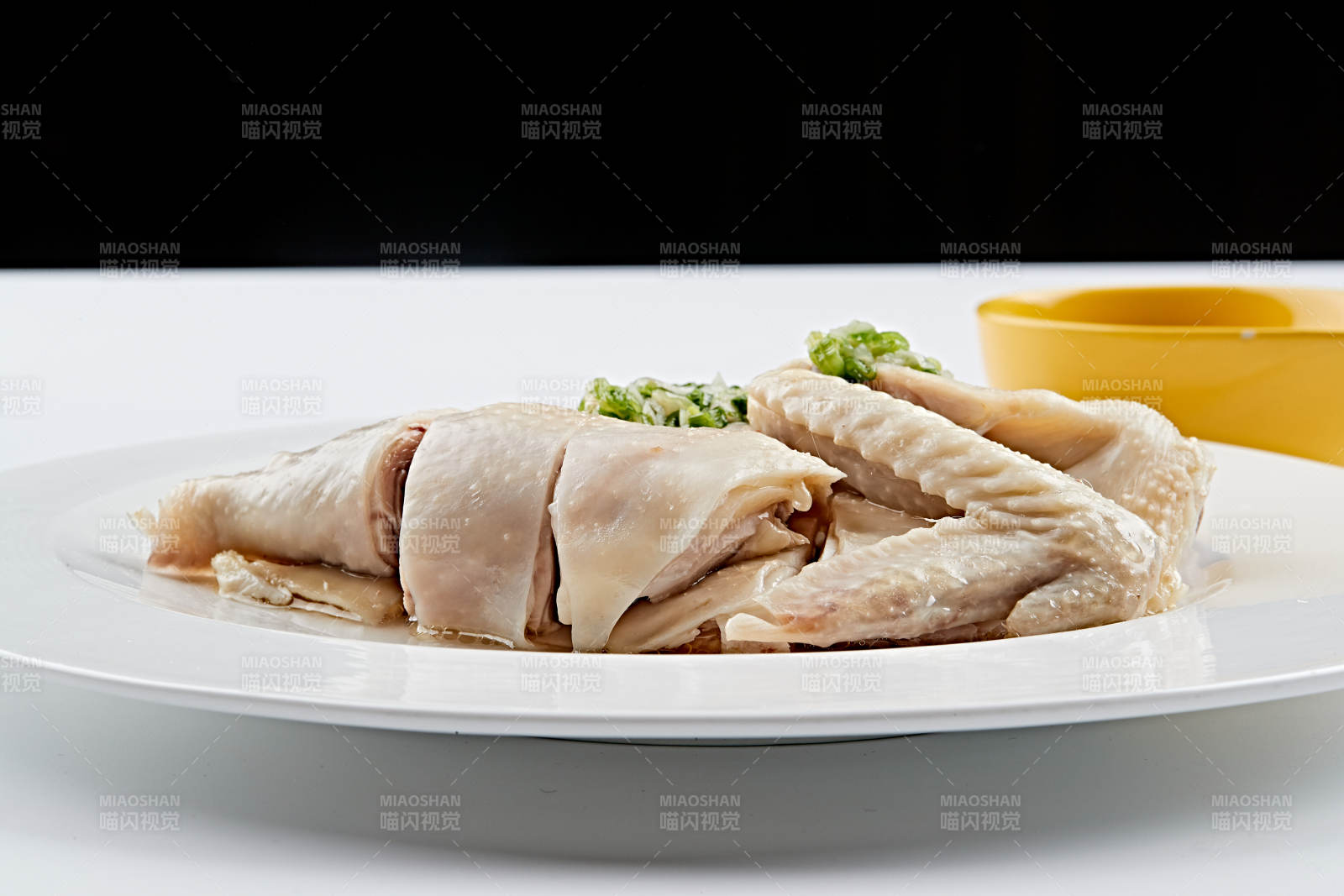 白色盘装的广式蘸汁白切鸡图片