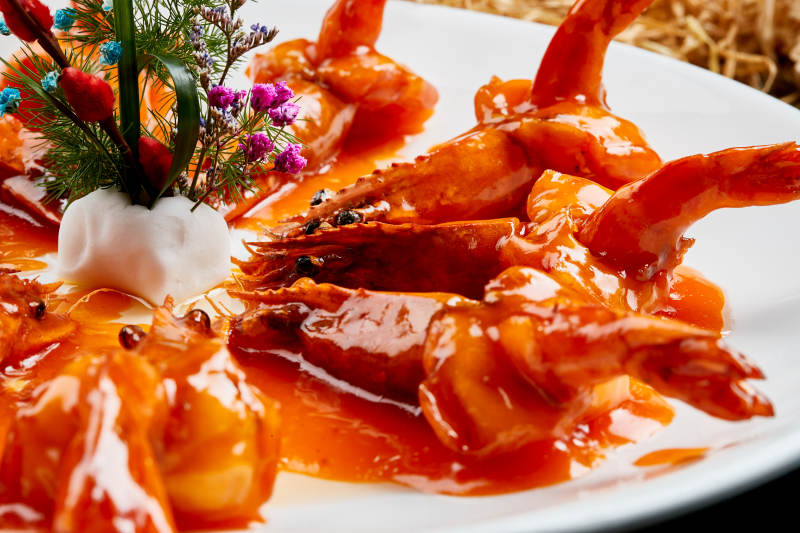 白色瓷盘装的浇汁油炸开背大明虾图片