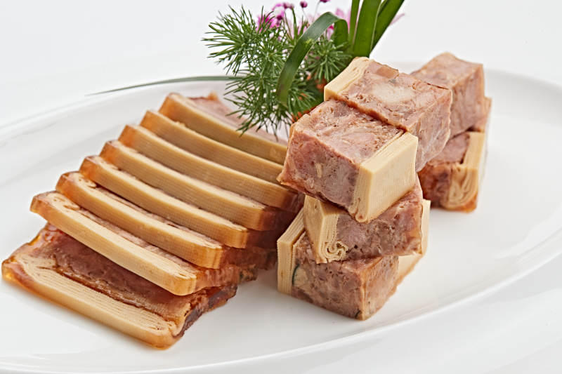 白色瓷盘装的熏豆皮压熏肉图片