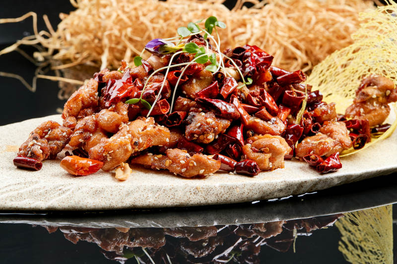 精美餐具装的香辣豆苗鸡腿肉图片