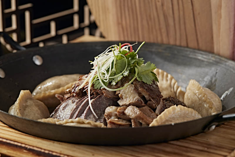 农家灶台铁锅炖猪杂配莜面蒸饺图片