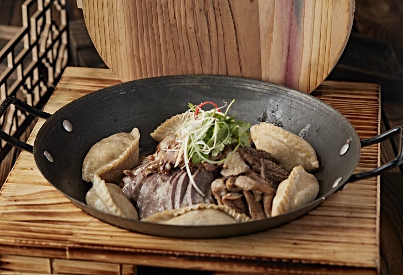 农家灶台铁锅炖猪杂配莜面蒸饺图片