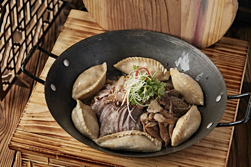 农家灶台铁锅炖猪杂配莜面蒸饺图片