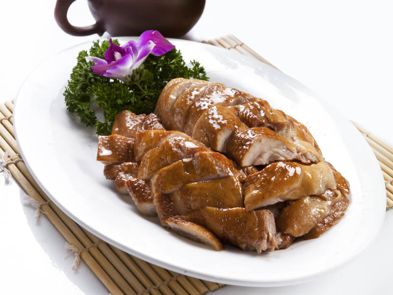 白色瓷盘装的分切红烧鸡腿肉图片