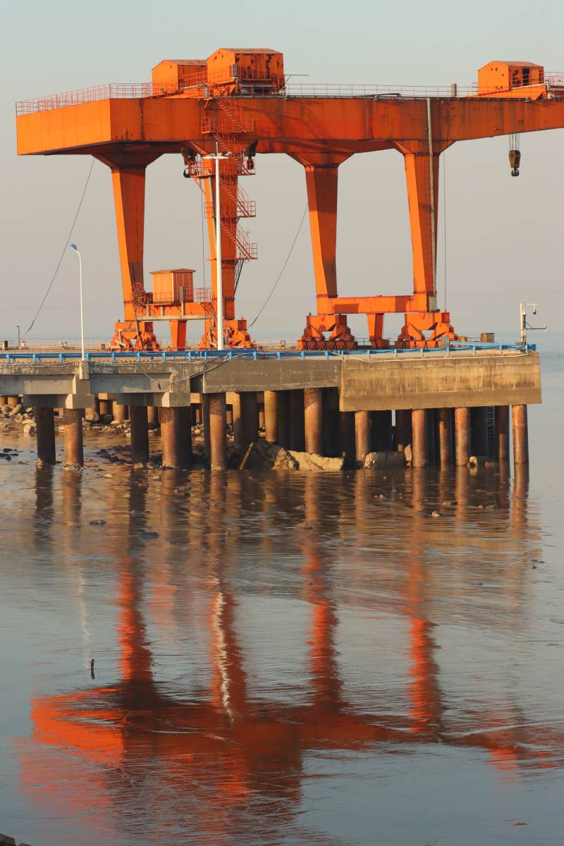钱塘湿地公园钱塘江边橙色港口起重机倒影图片