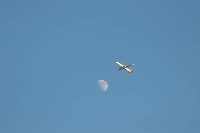 钱塘湿地公园钱塘江边飞机掠过月亮图片