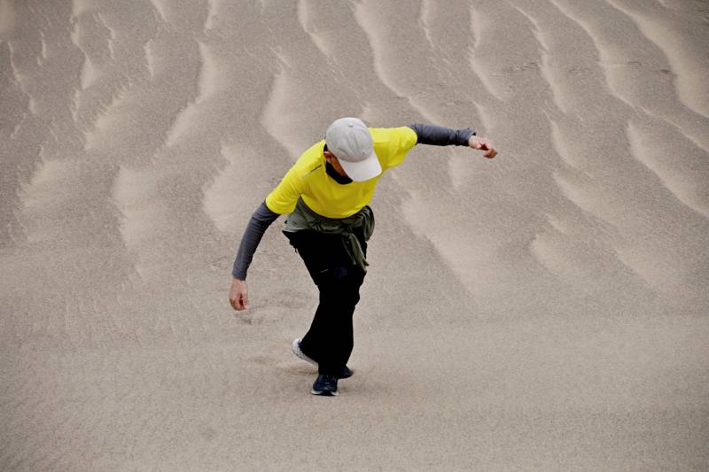 罗布泊沙漠中攀登沙山者图片