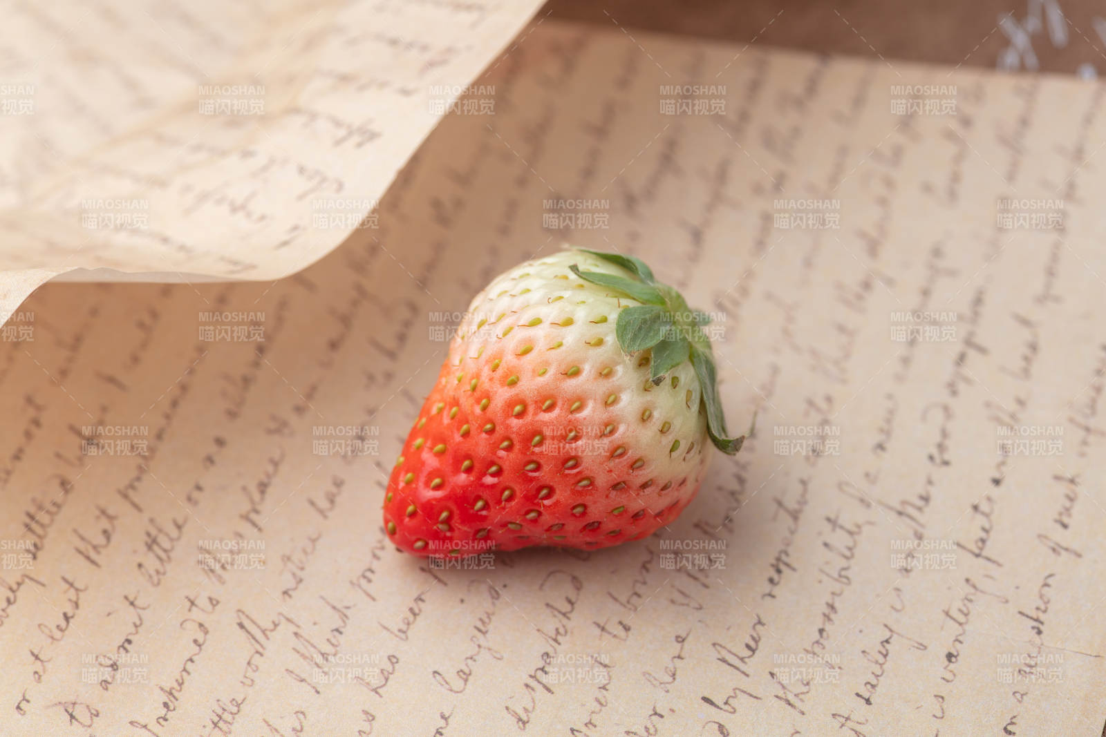 草莓静置于信笺上图片