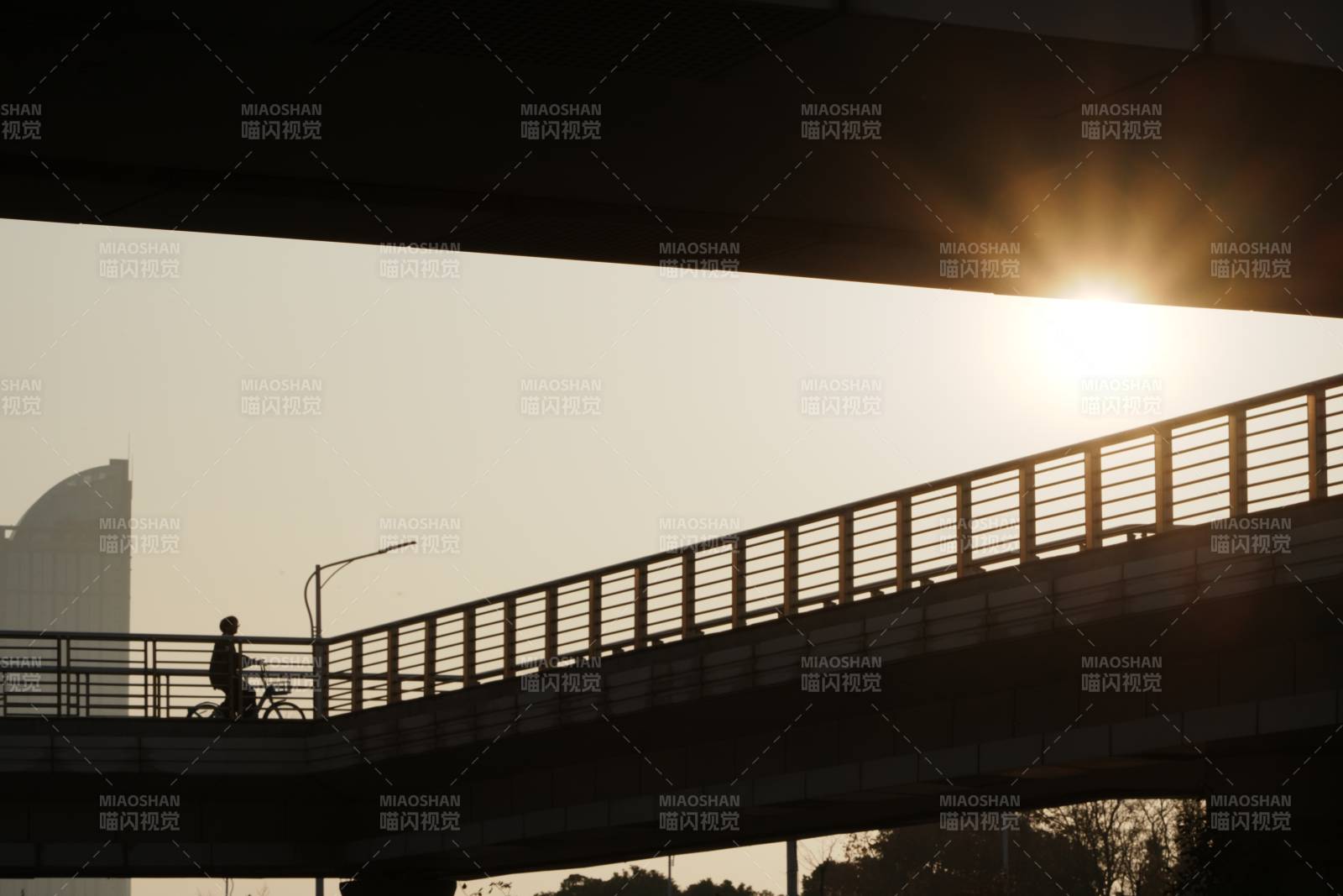 城市天桥上骑行剪影图片