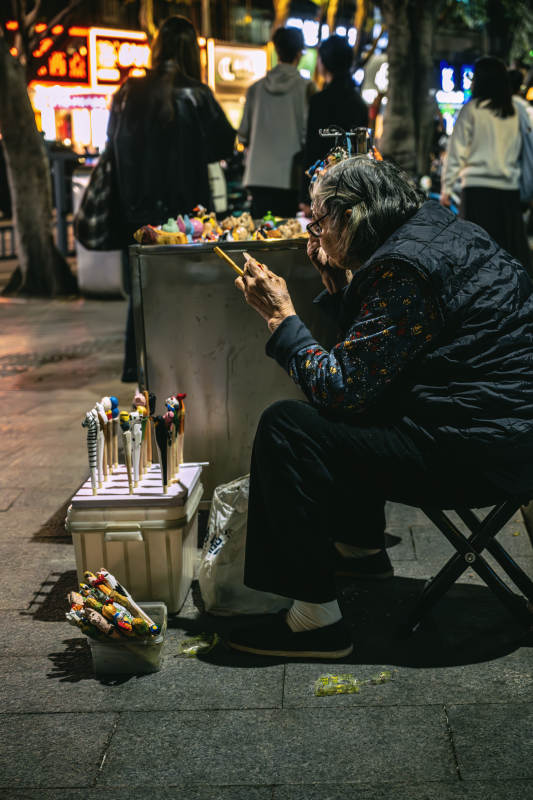 街头艺人夜市卖糖画图片
