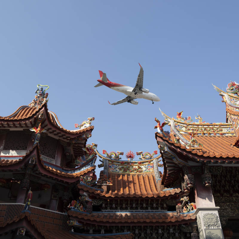 飞机掠过朝天宫古庙屋顶图片
