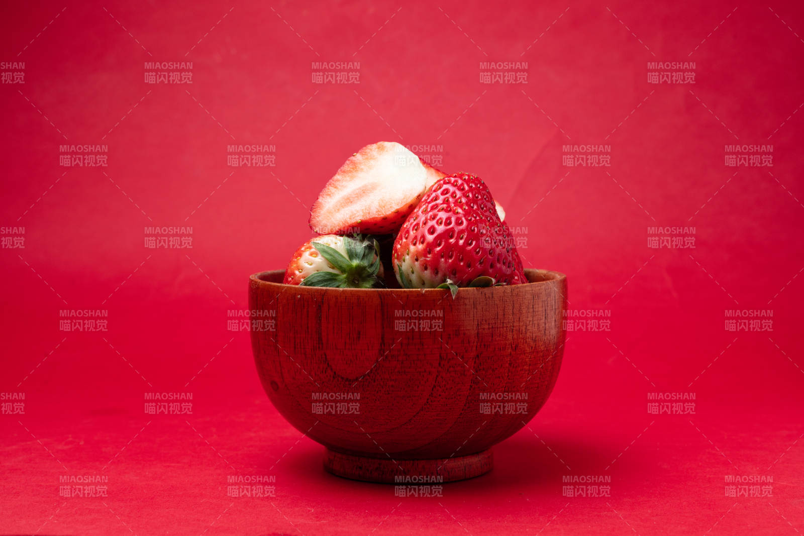 草莓木碗红背景图片