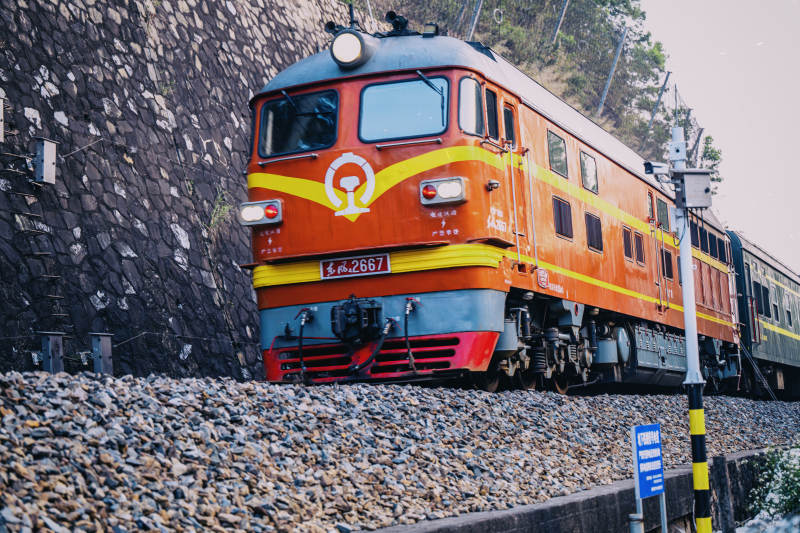 橙色火车穿行山间图片
