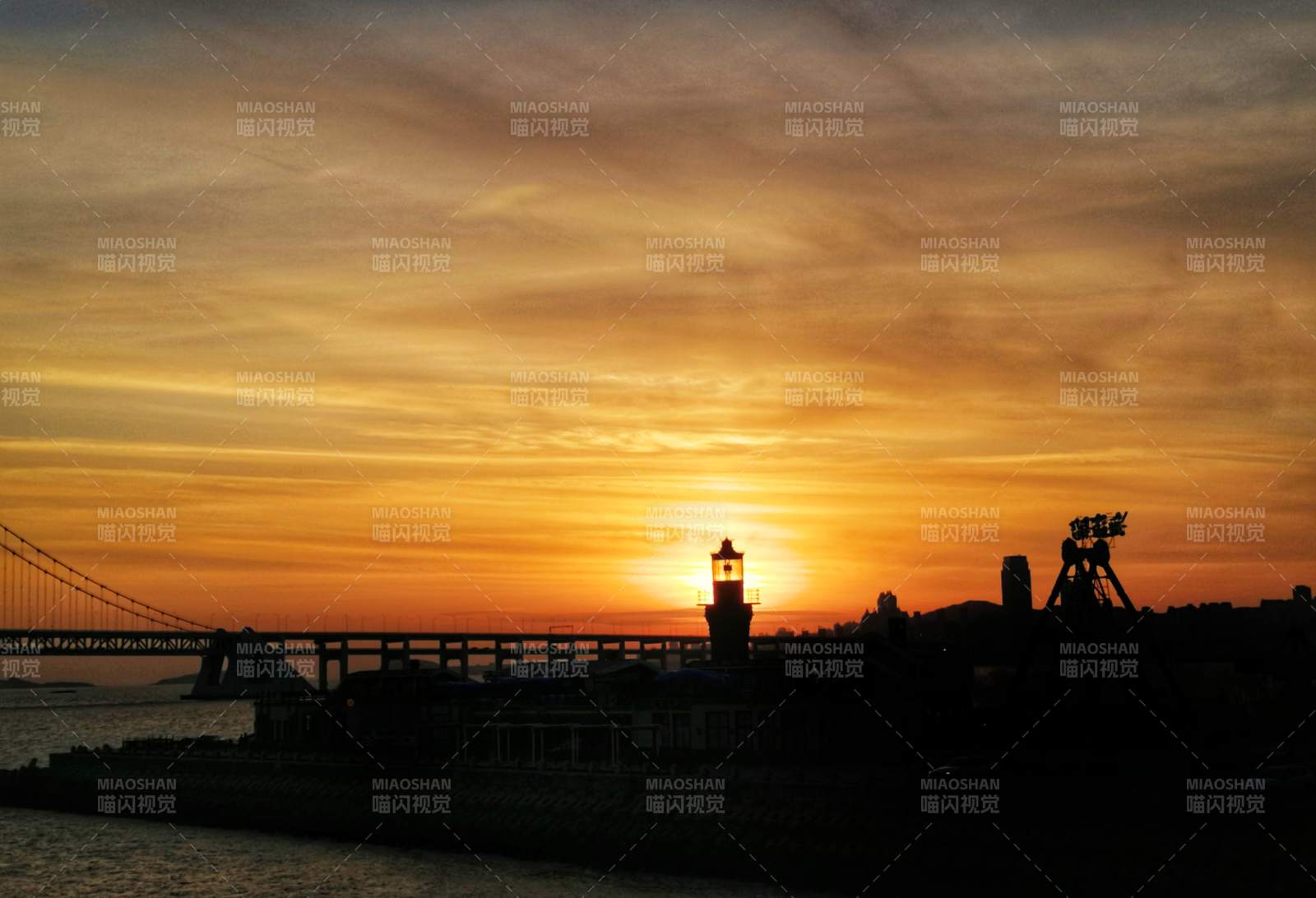 夕阳下的灯塔剪影图片