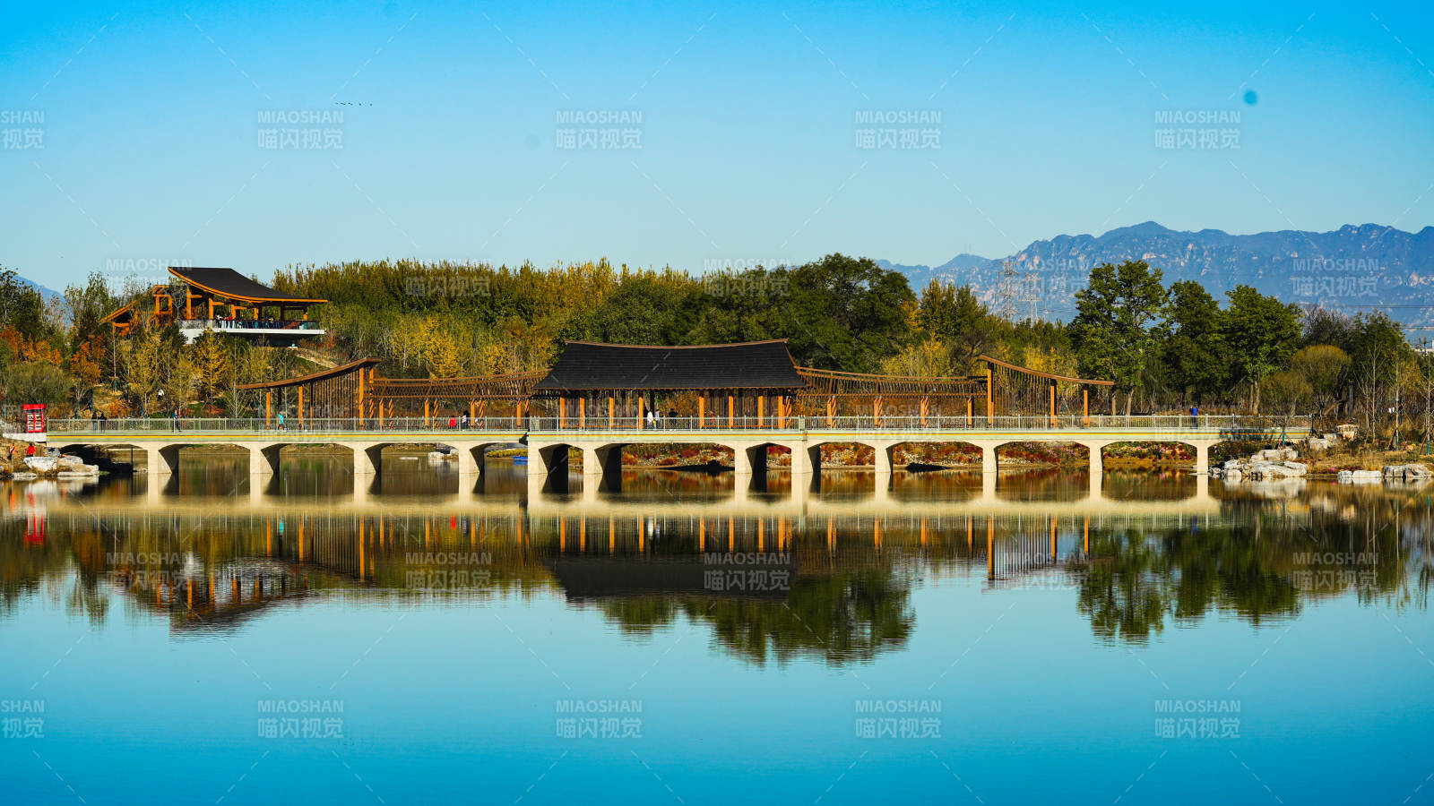 北京玉河湿地公园湖畔长桥倒影图片