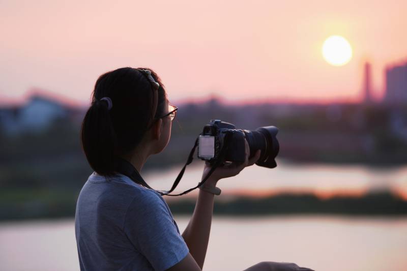 夕阳下拍照的女孩图片