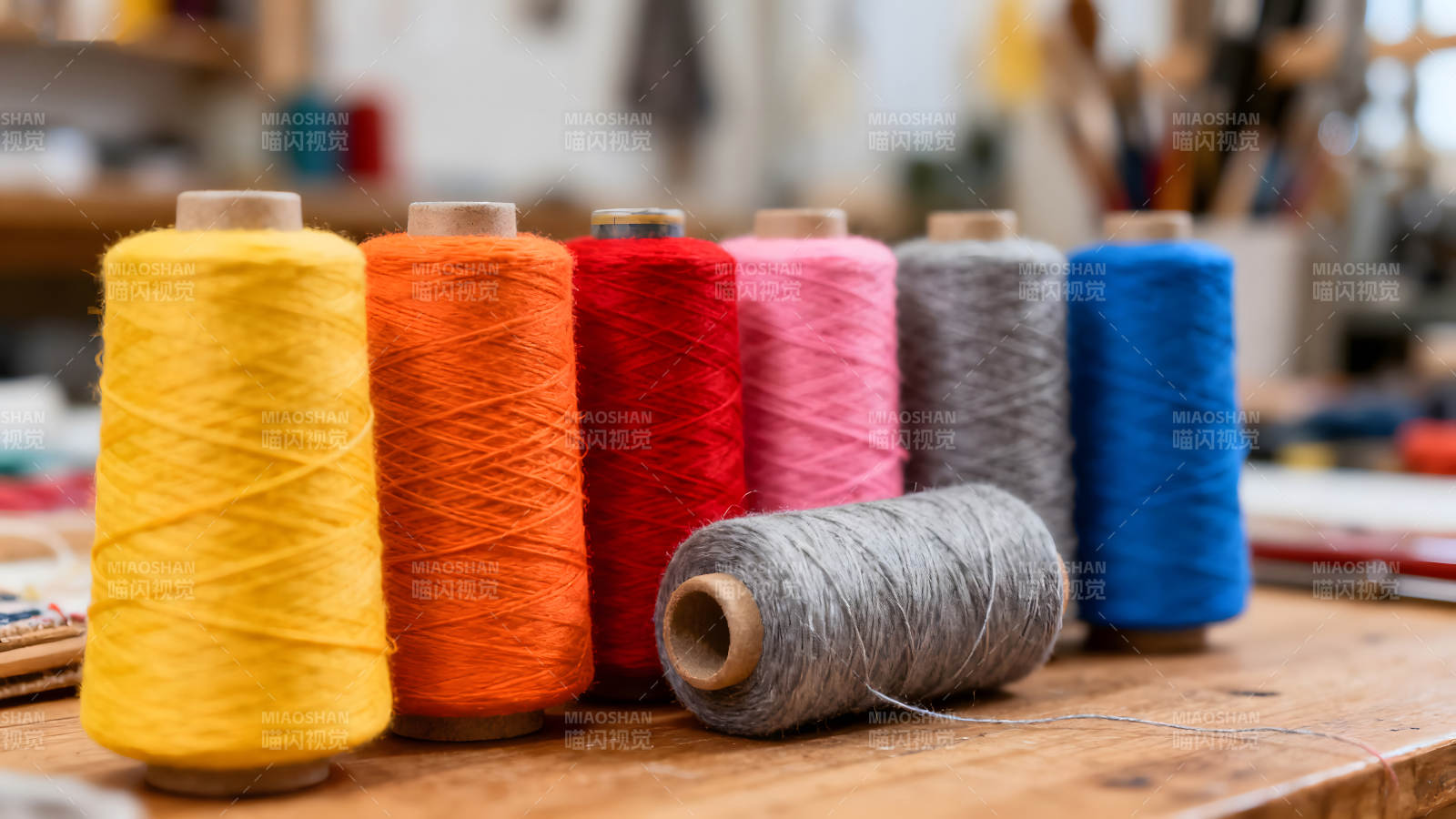 五彩线轴排列在木桌上图片