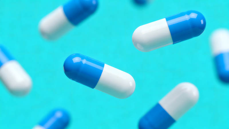 药丸悬浮在蓝色的背景上图片
