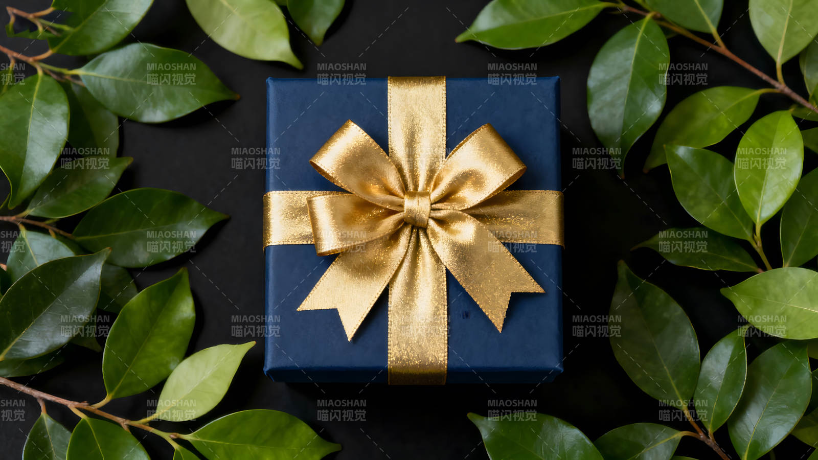精美礼盒金色丝带与绿叶点缀图片