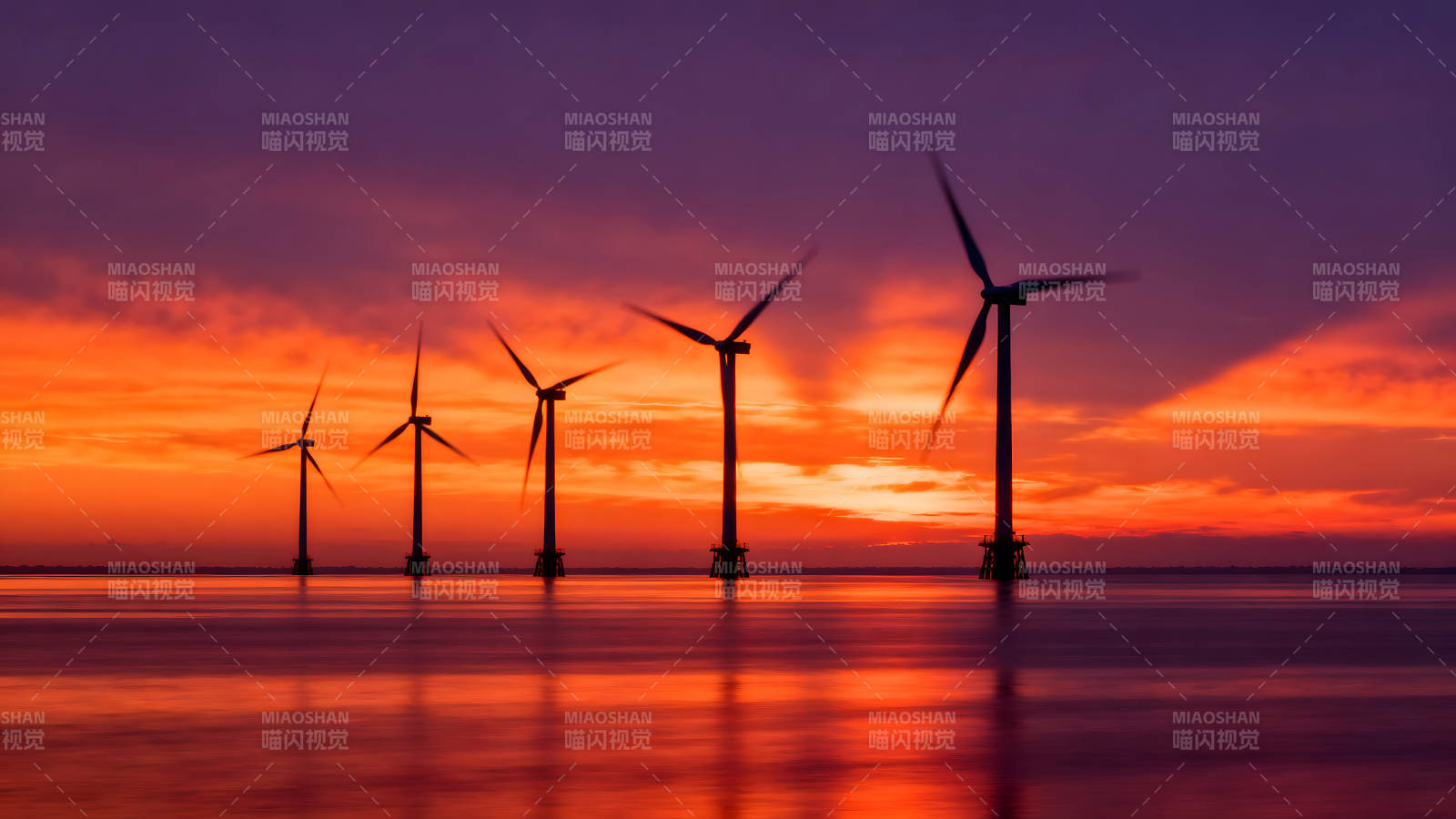 风车在海面上旋转落日余晖照耀图片