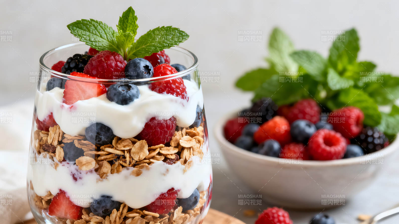 美味的水果酸奶杯配有薄荷叶装饰图片