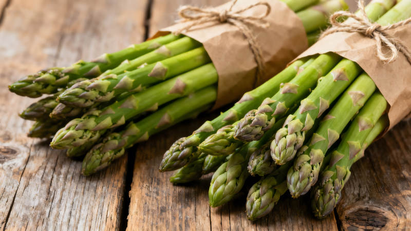 新鲜的芦笋捆绑在一起置于木板上图片