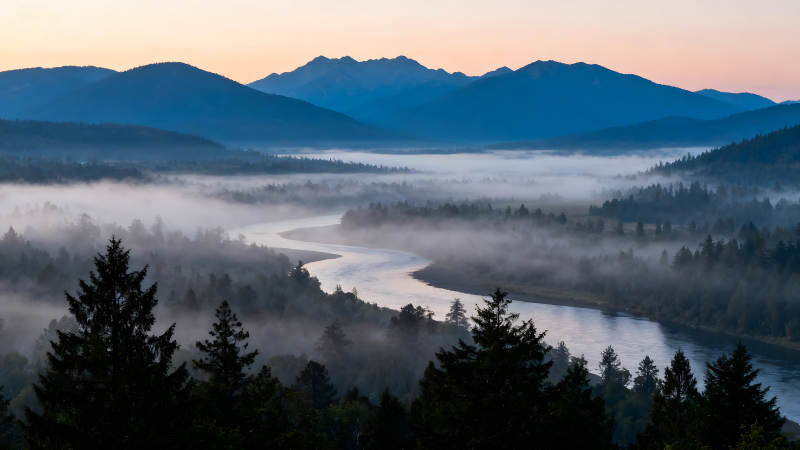 蜿蜒河流穿过山谷云雾缭绕的景象图片