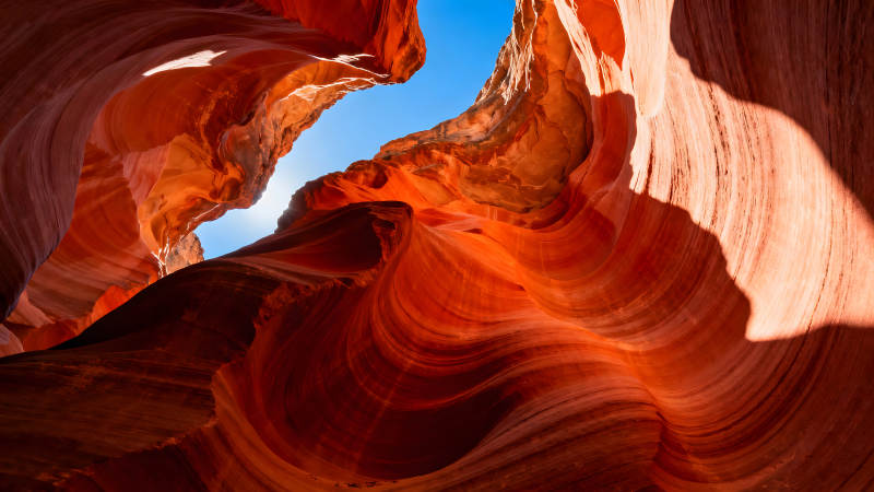 峡谷内部仰视视角呈现的橙红色岩壁结构图片