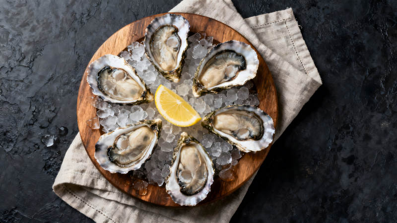 生蚝拼盘配柠檬和冰块图片