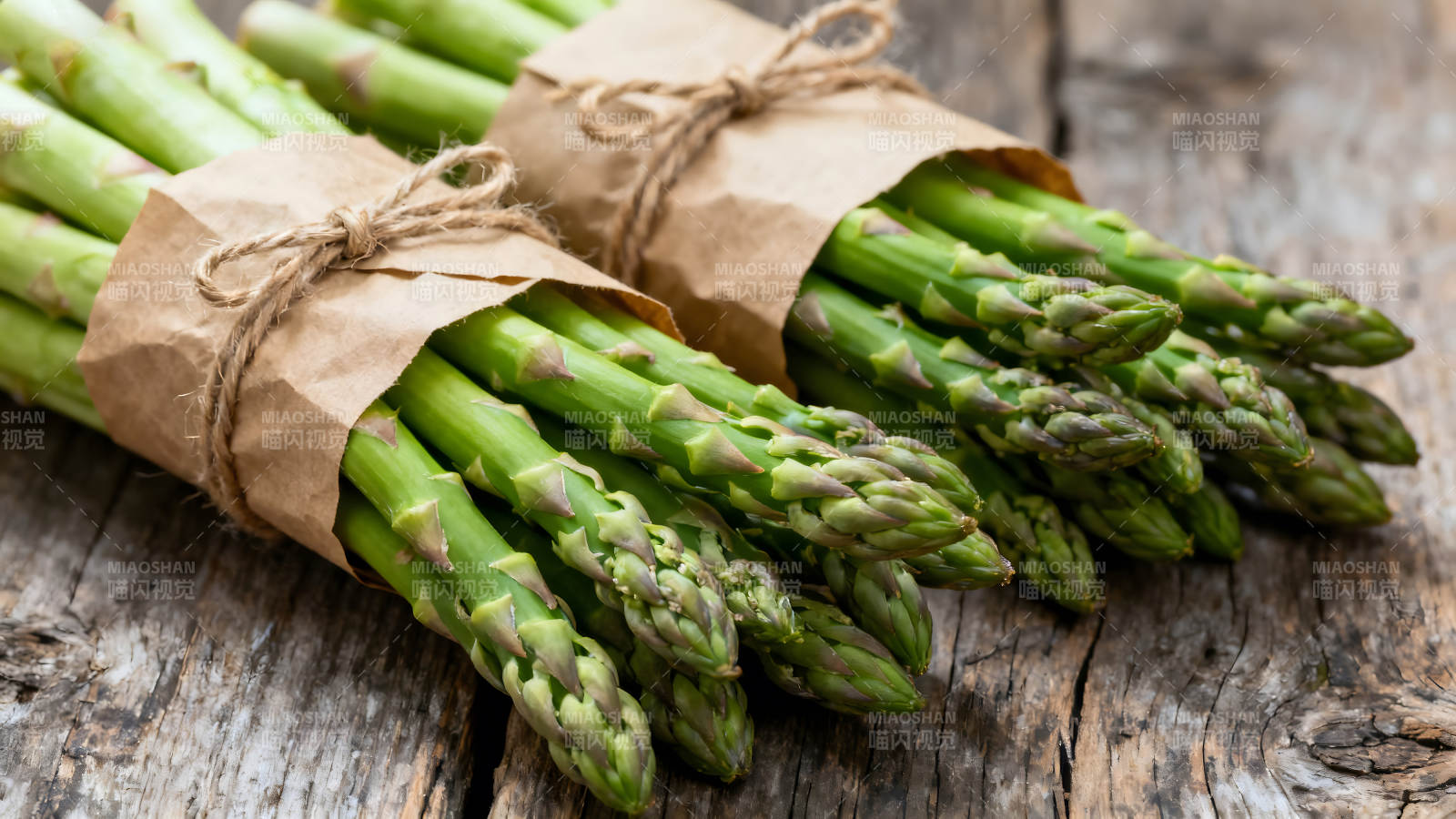 两束新鲜的芦笋用纸包裹着图片