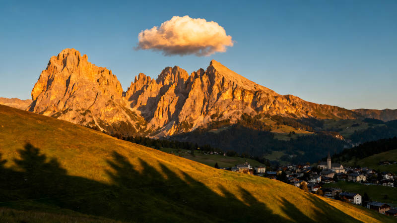 金色山峰下的村庄和云朵图片