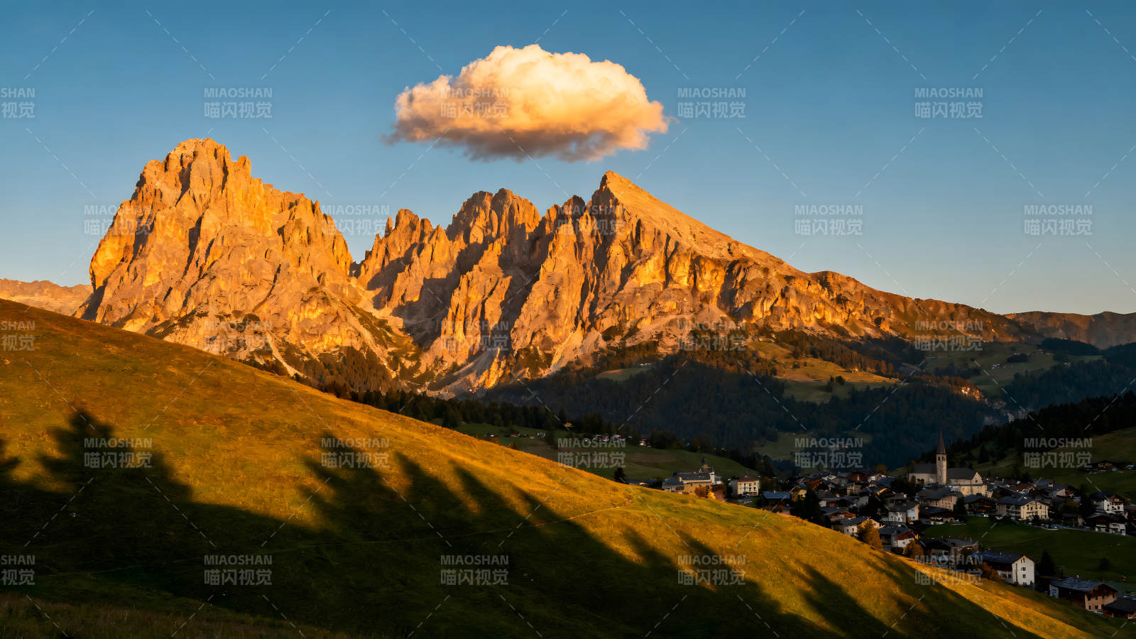 金色山峰下的村庄和云朵图片