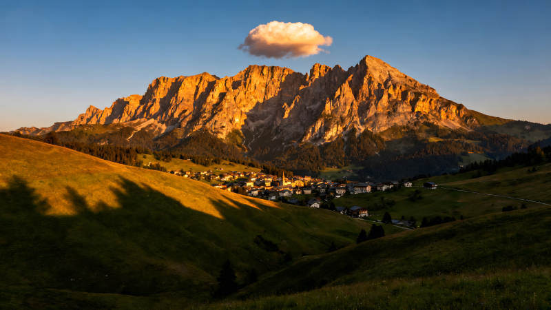 金色山脉下的村庄蓝天白云图片