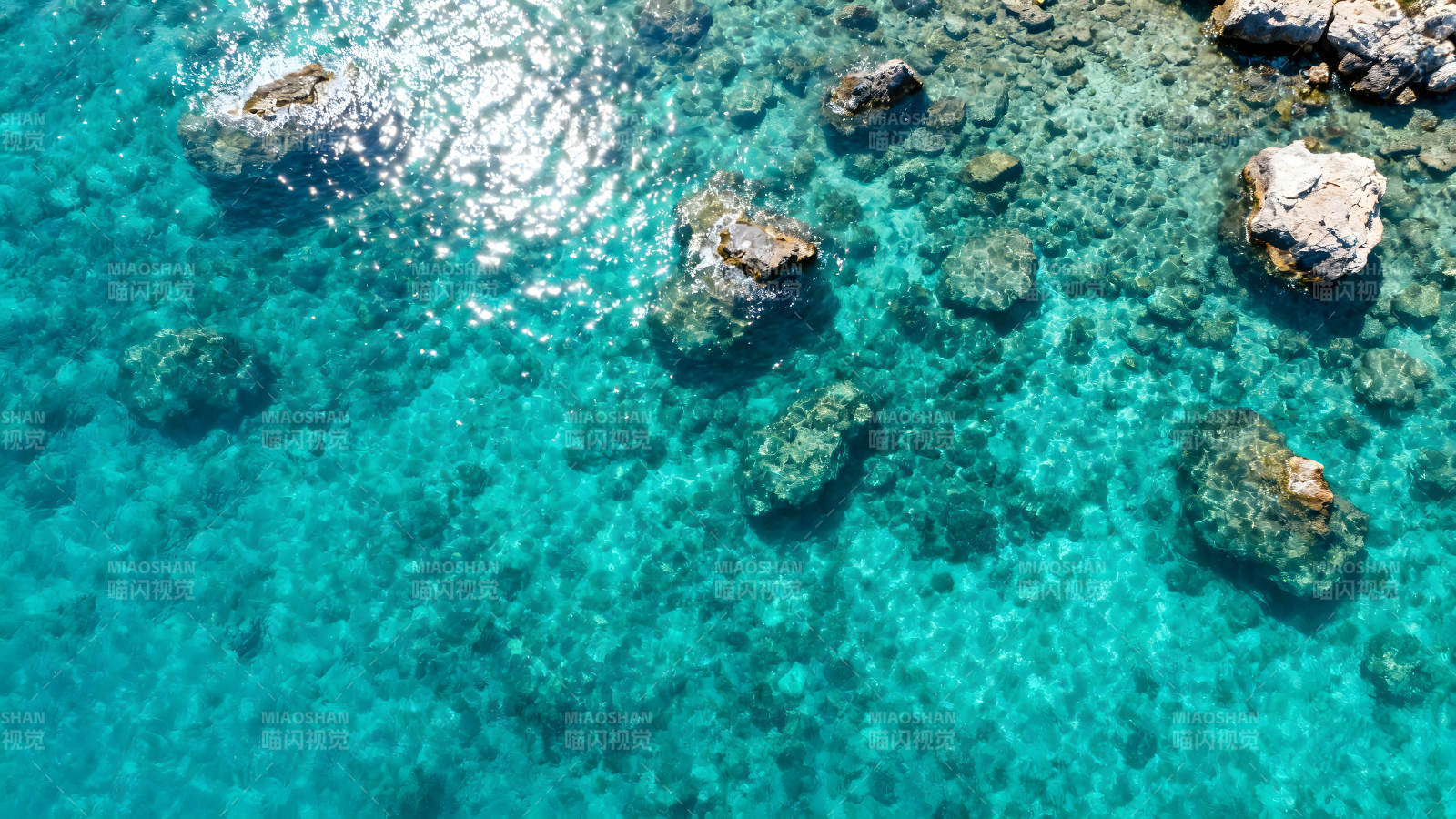 碧海礁石阳光下的海面图片