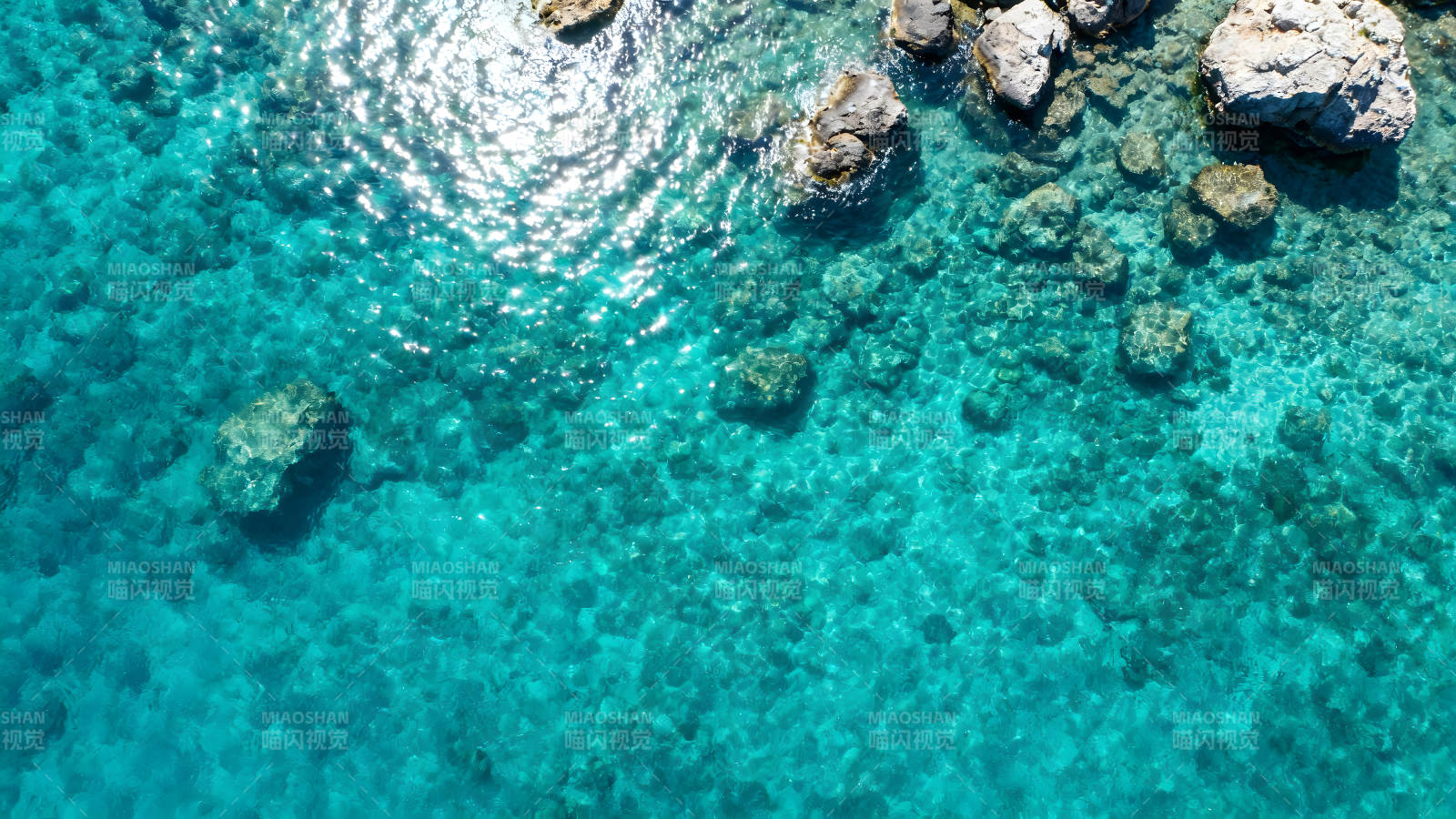 碧海蓝天下的岩石与清澈海水图片