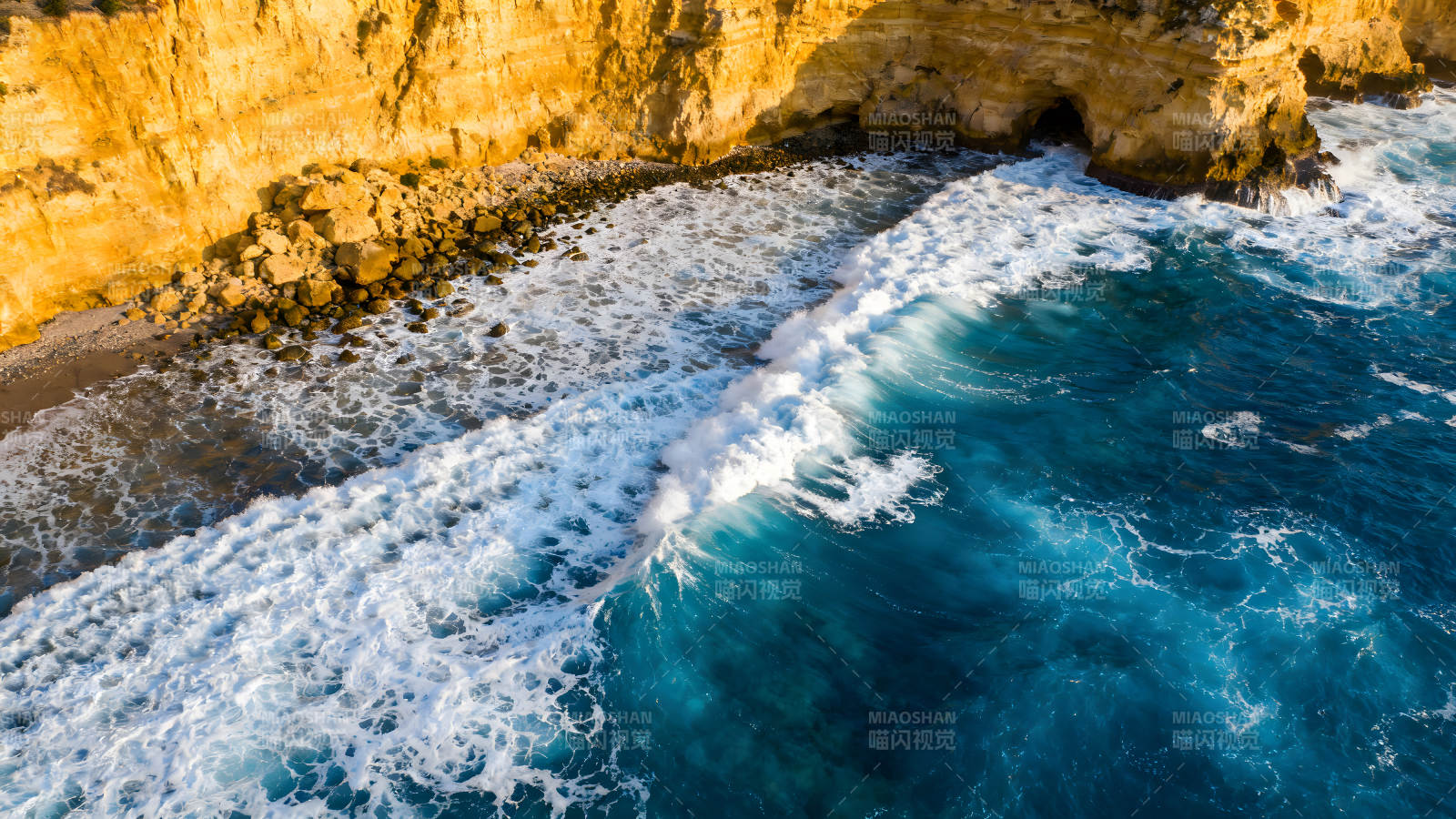 海浪拍打金黄悬崖景象图片