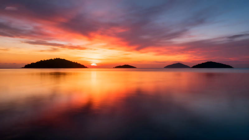 夕阳下的岛屿倒影宁静而壮丽图片