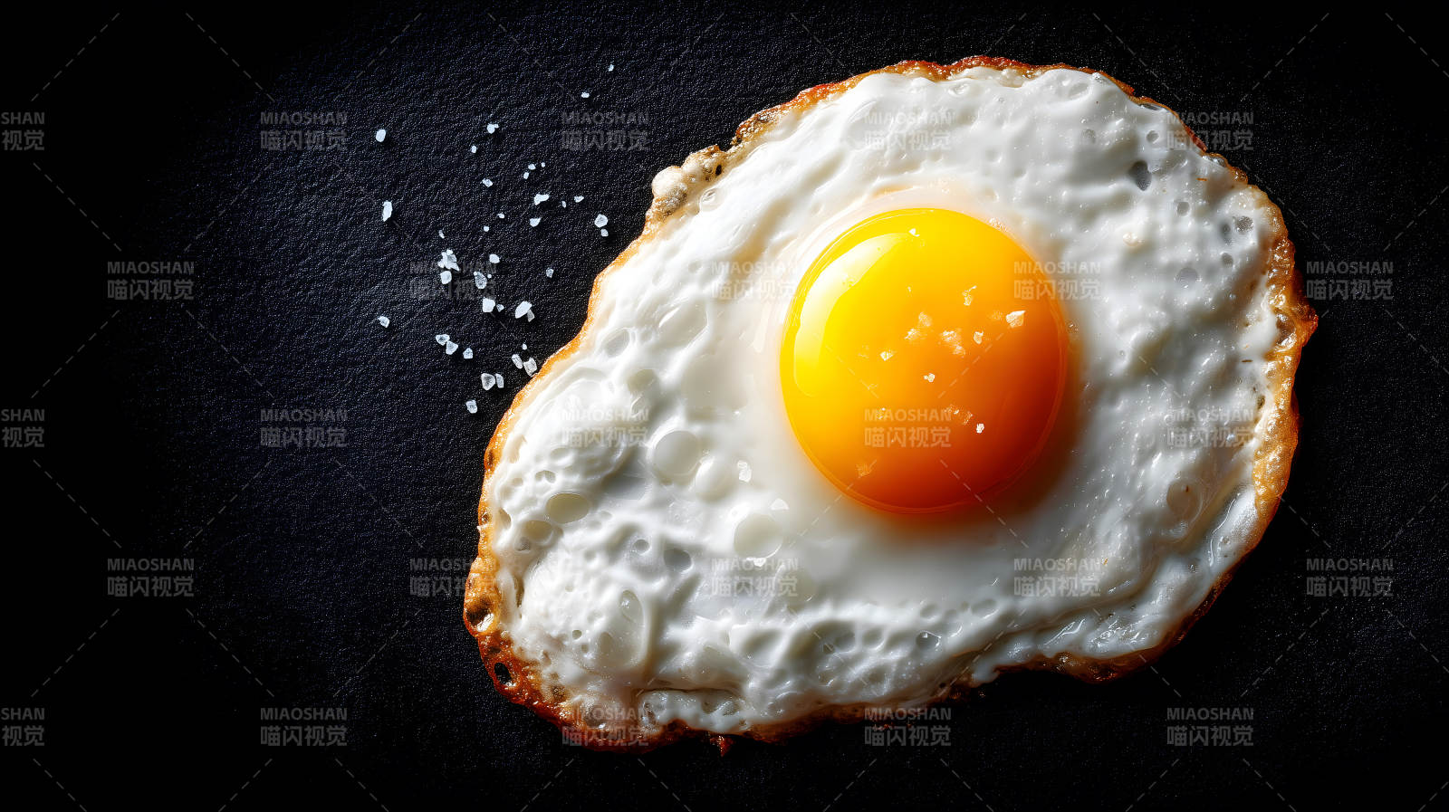 诱人的煎蛋撒上盐粒图片