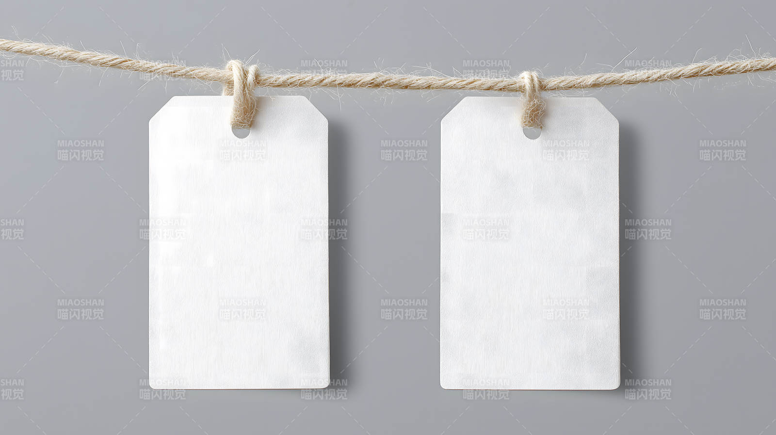 两张白色标签挂在绳子上背景为灰色图片