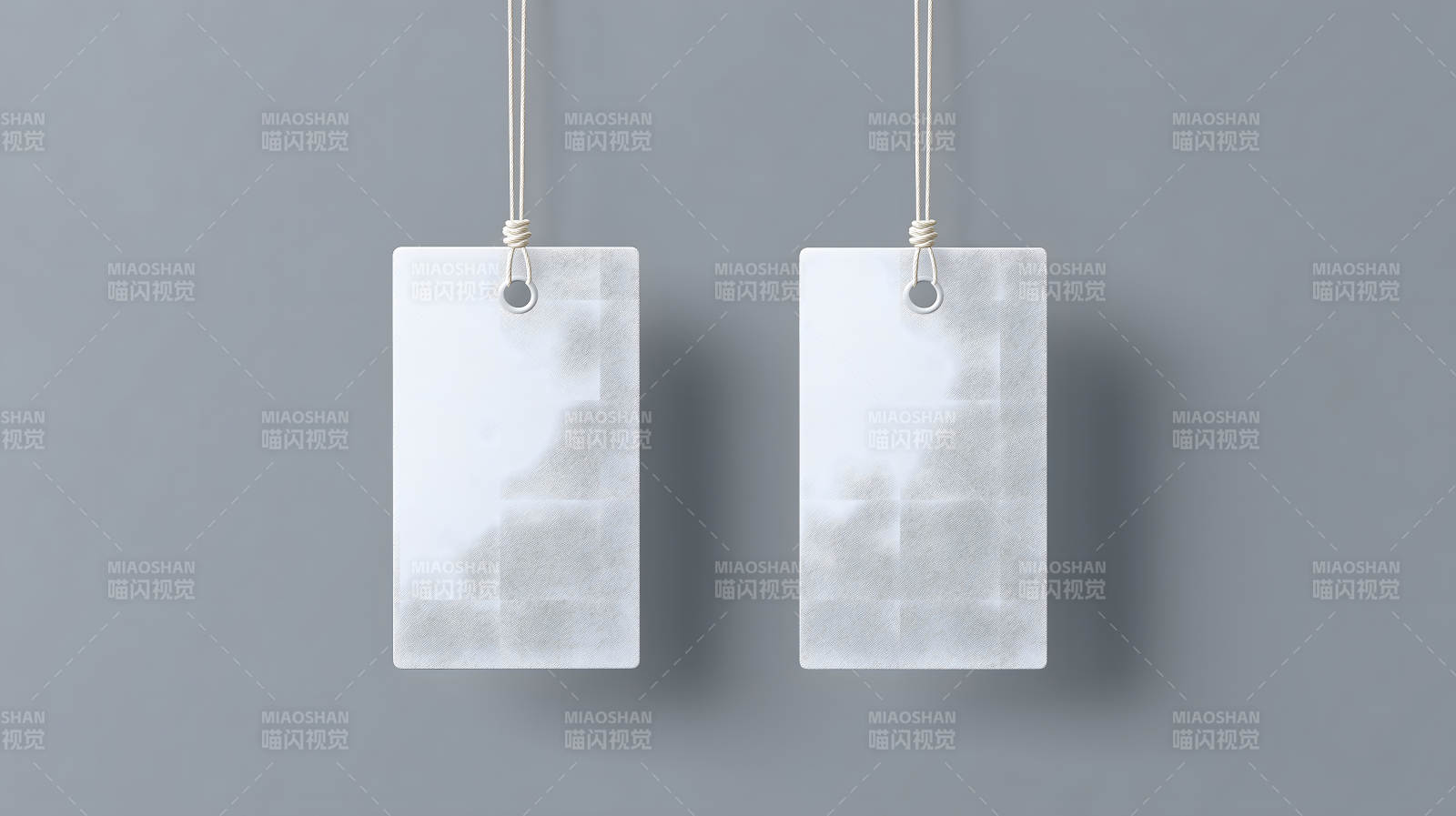 两张白色标签悬挂在灰色背景上图片
