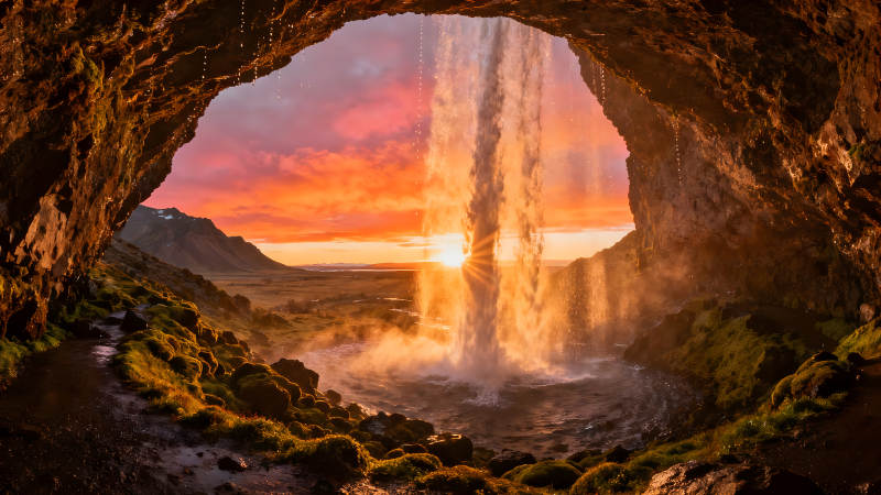 瀑布夕阳下的岩洞风光图片