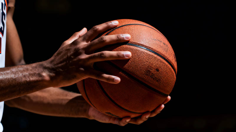 篮球手托球特写黑暗背景图片