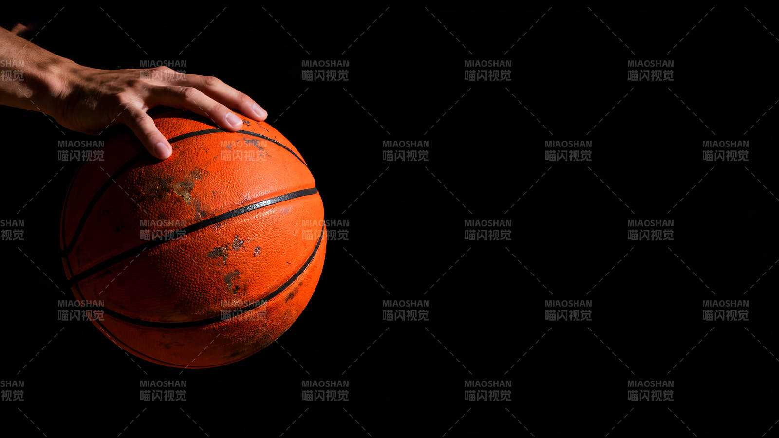 手握篮球黑色背景光线充足图片