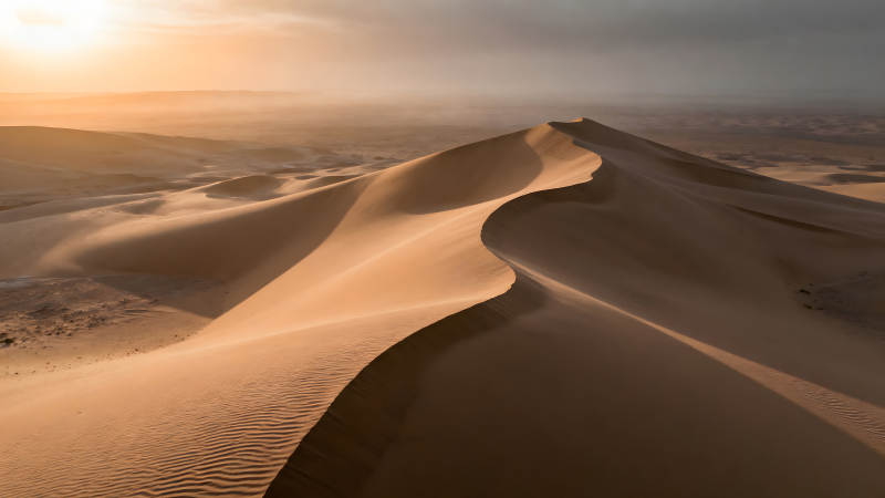 沙漠沙丘在阳光下形成曲线图片