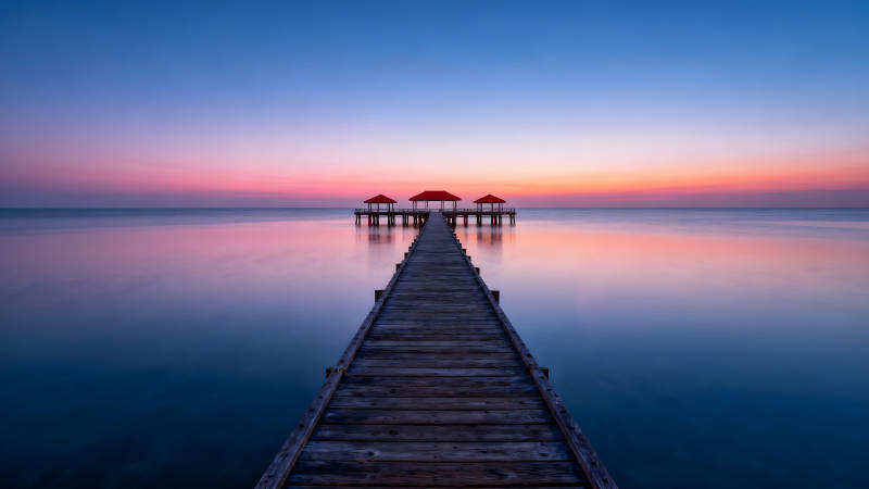 海边长廊日出景象天空被色彩晕染图片