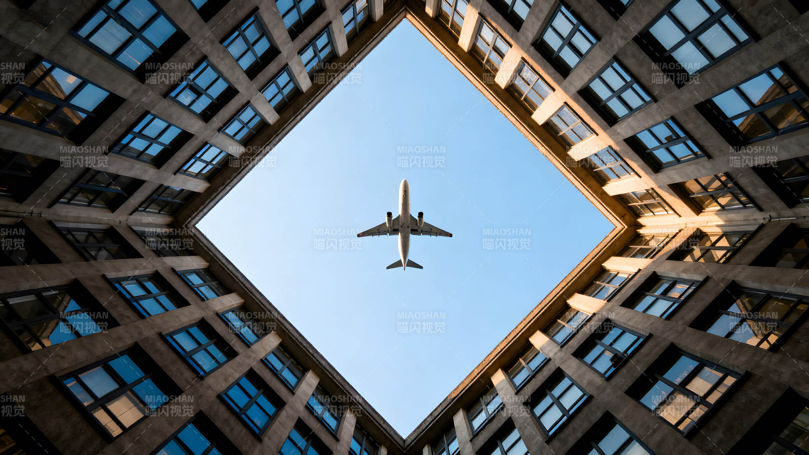 飞机穿梭楼宇天空俯瞰图片