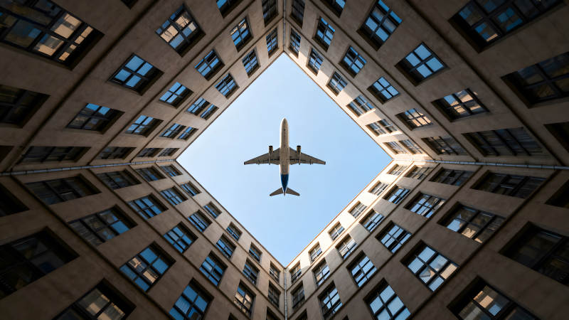 飞机穿过建筑物的方形天空图片