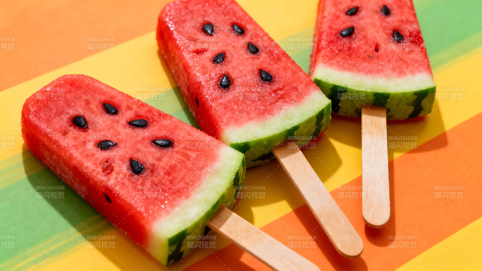 西瓜棒冰在彩色背景上图片