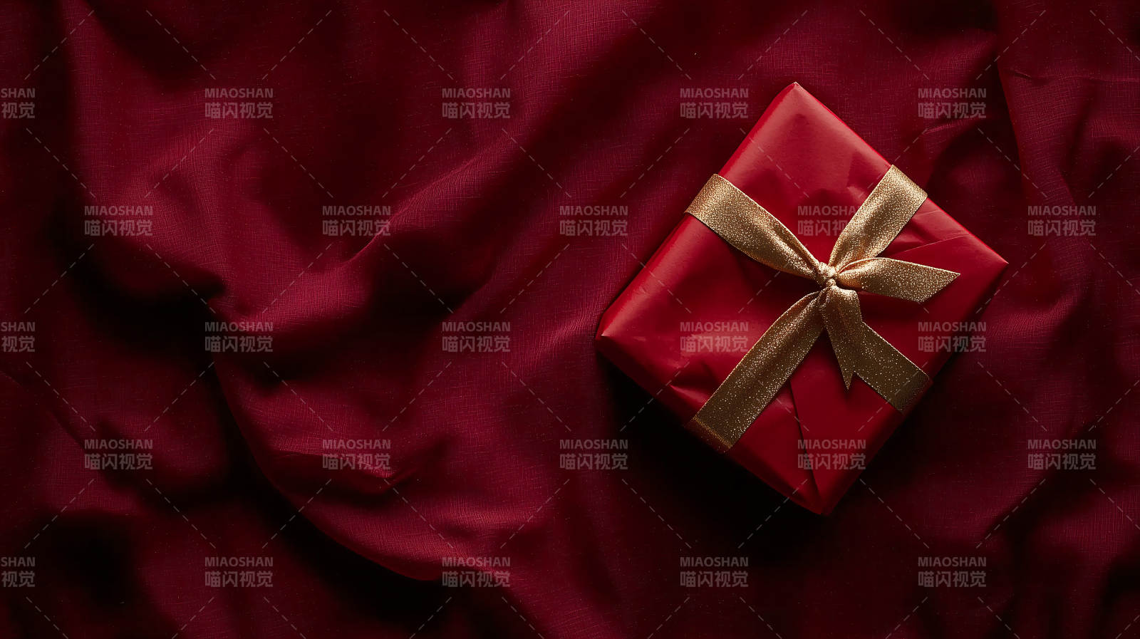 深红色礼盒上的金色丝带图片